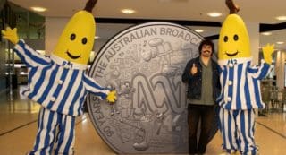 Tony Armstrong with Bananas in Pyjamas alongside ABC commemorative coin